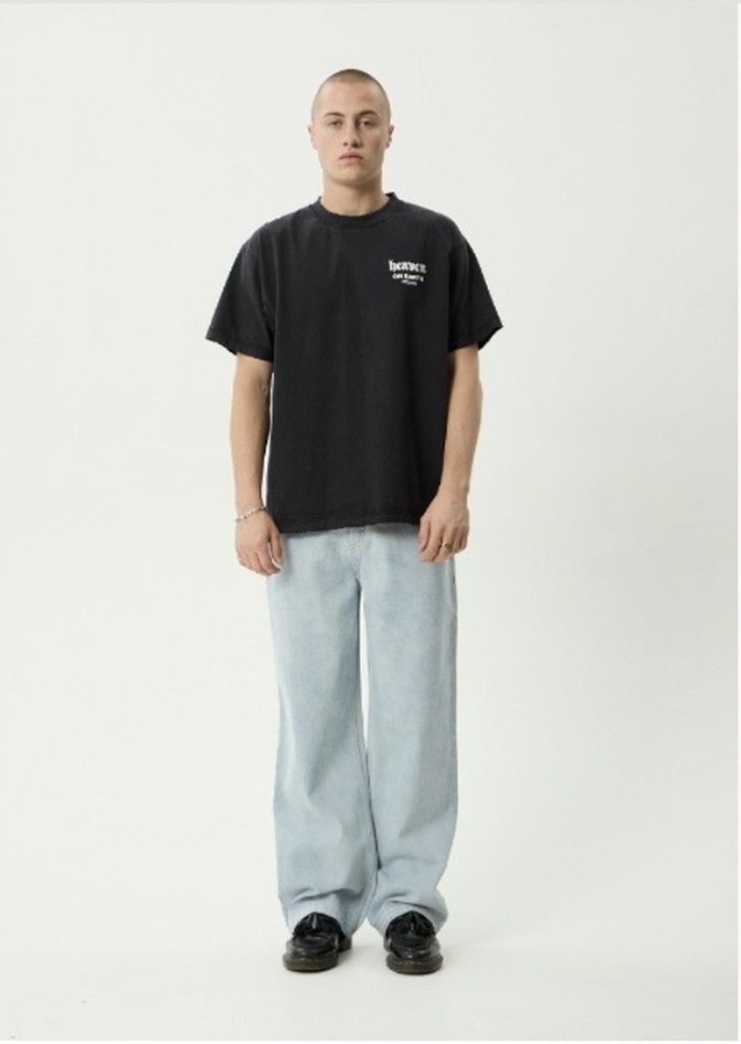 A model in a black t-shirt and light wash jeans, the starting photo.